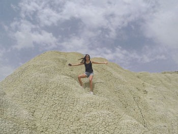 Woman standing on beach against sky