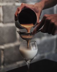 Close-up of hand pouring wine in glass