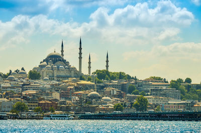 Yeni cami mosque in city by sea against sky