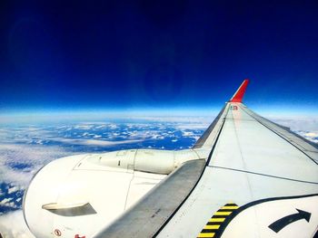 Close-up of airplane wing against blue sky