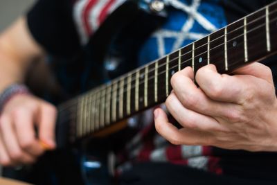 Midsection of man playing guitar