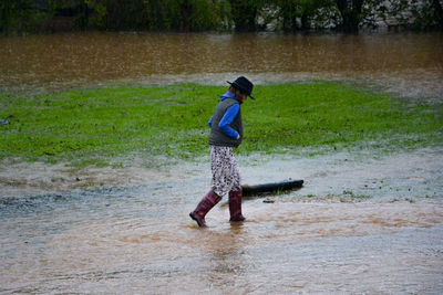 Girl walking in muddy water during rainy season