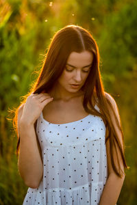 Young beautiful woman in white dress in corn field.