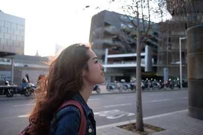 Portrait of young woman looking at city