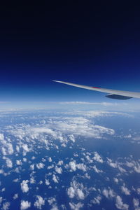 Aerial view of airplane wing against blue sky