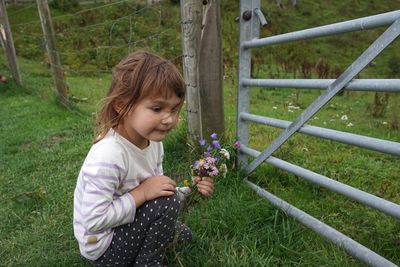 Full length of girl holding flowering plants