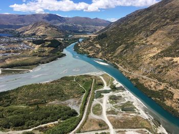 High angle view of river amidst mountains against sky