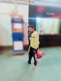 Side view of young man looking at camera