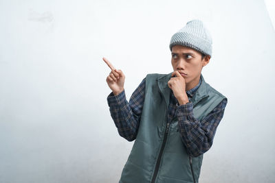 Young man standing against wall