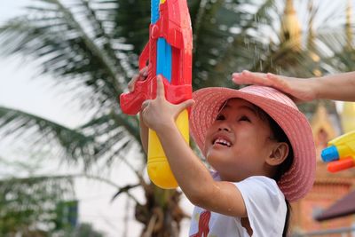 Boy holding hat looking away