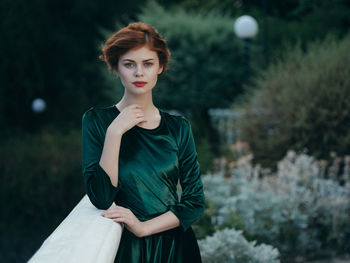 Full length of young woman standing against trees