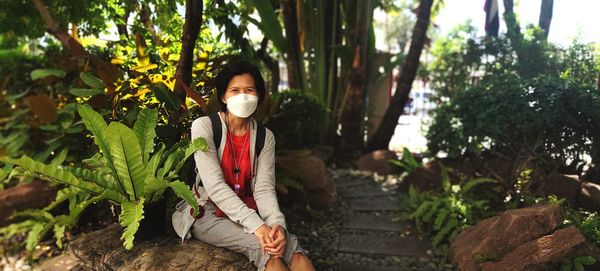 Young woman standing against trees