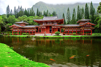 Built structure by lake against trees