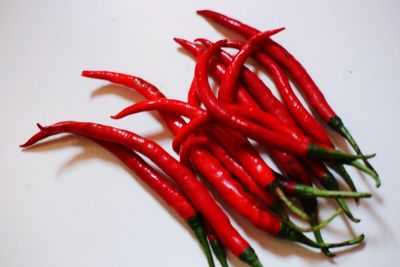 Close-up of red chili peppers against white background