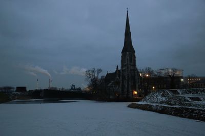 Illuminated building against sky during winter