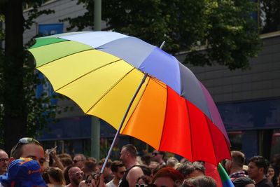 Crowd holding umbrella in city