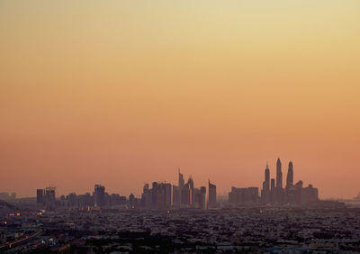 Modern buildings against sky during sunset