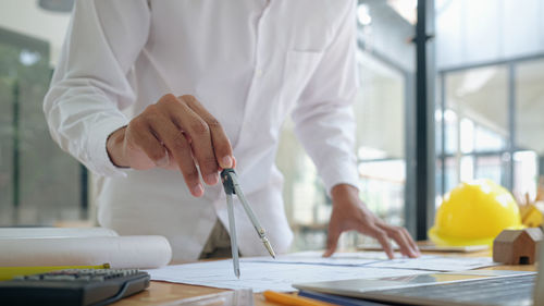 Midsection of man working on table