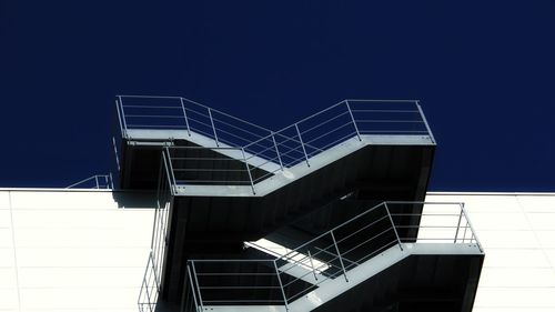 Low angle view of office building against clear blue sky