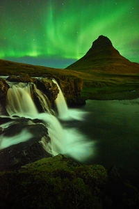 Scenic view of waterfall against sky at night