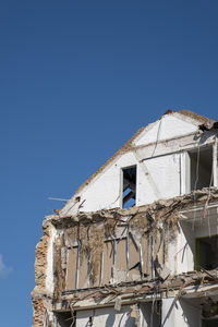 Low angle view of old building against clear blue sky