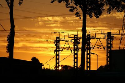 Silhouette of electricity pylon at sunset