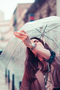 Woman adjusting umbrella during monsoon