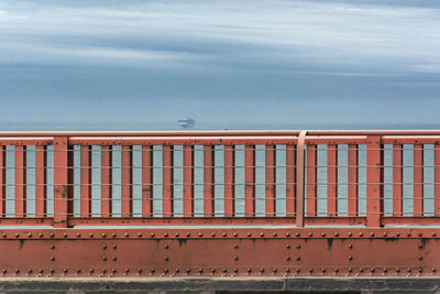 Railing by sea against sky