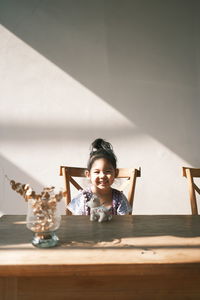 Portrait of boy sitting on table
