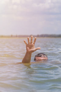 Cropped image of person drowning in sea