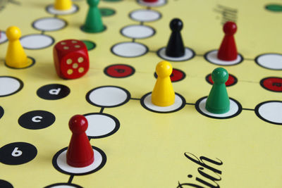 Close-up of game pieces and dice on ludo