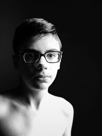 Close-up portrait of teenage boy wearing eyeglasses with band aid on nose