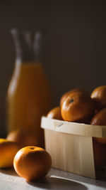 Freshly harvested clementines in basket with fresh juice on the table . healthy eating, orange 