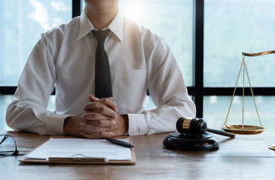 Midsection of lawyer working at desk in office