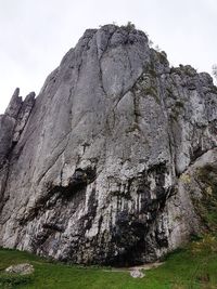 Low angle view of rocky mountain against sky