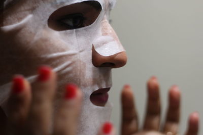 Close-up of woman using facial mask at home