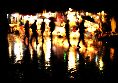 Silhouette people at illuminated city at night