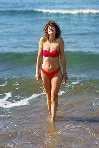 Young woman in bikini standing at beach