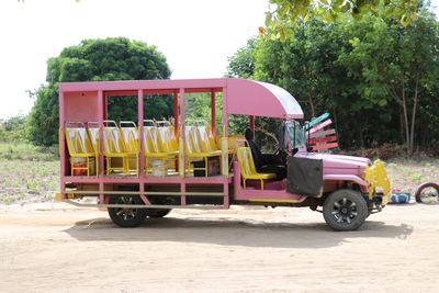 Bus on dirt road against trees