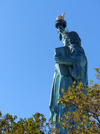 Trees against statue of liberty