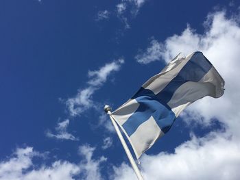 Low angle view of flag against blue sky