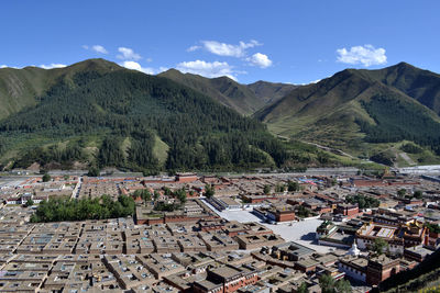 Aerial view of townscape and mountains against sky