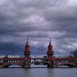 Bridge over river against cloudy sky