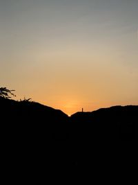 Silhouette landscape against clear sky during sunset