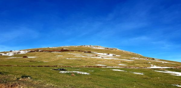 Scenic view of mountain against blue sky