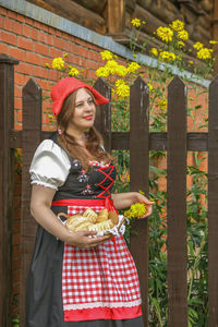 Portrait of young woman standing against trees