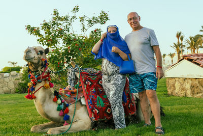 Rear view of man with dog on field