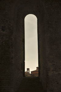 Low angle view of arch window against sky