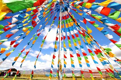 Multi colored flags hanging against sky