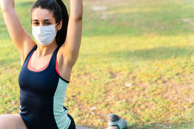 Midsection of woman with arms raised on field